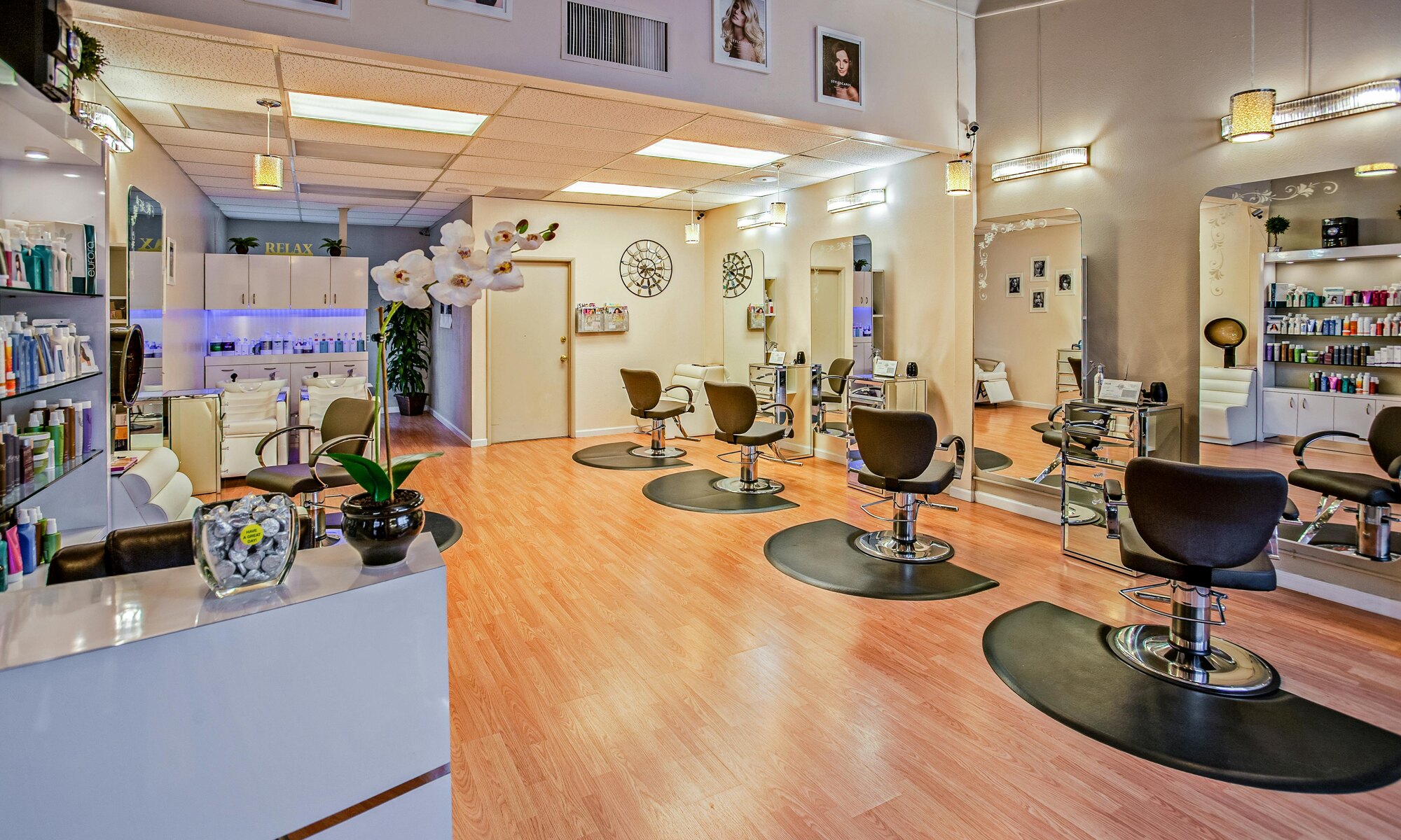 Warm, modern salon interior with styling stations and wood flooring