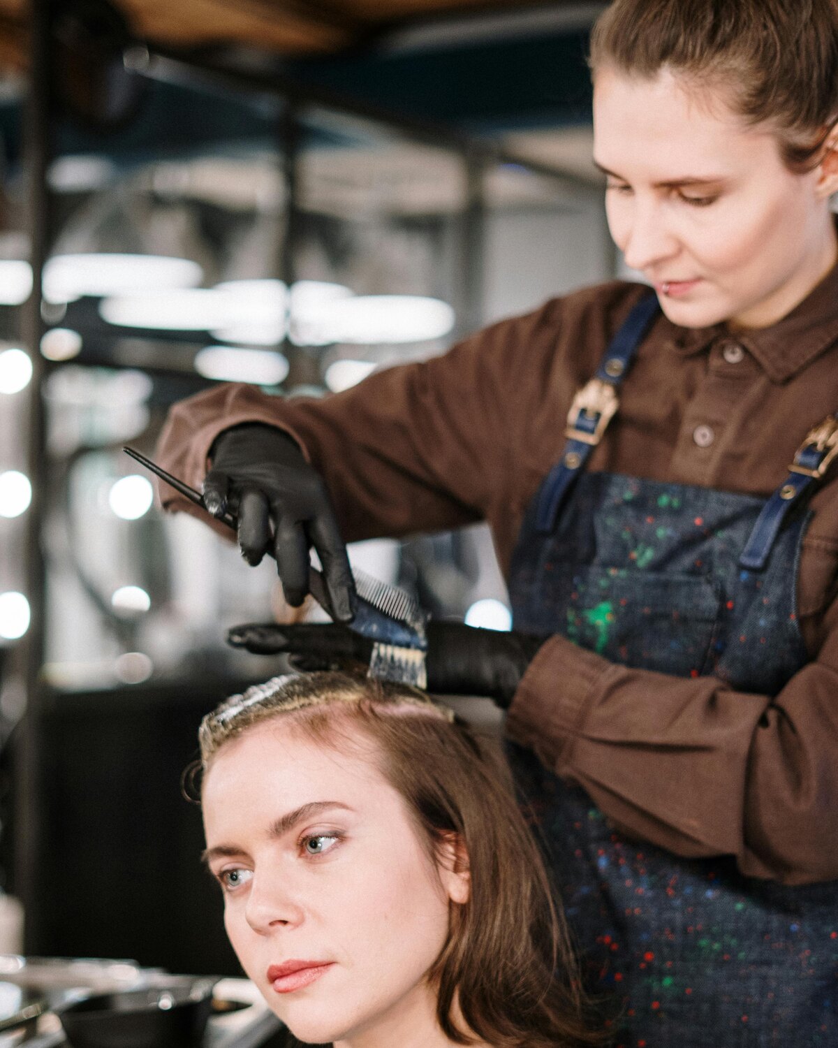 Stylist applying product to a client's hair during a salon service