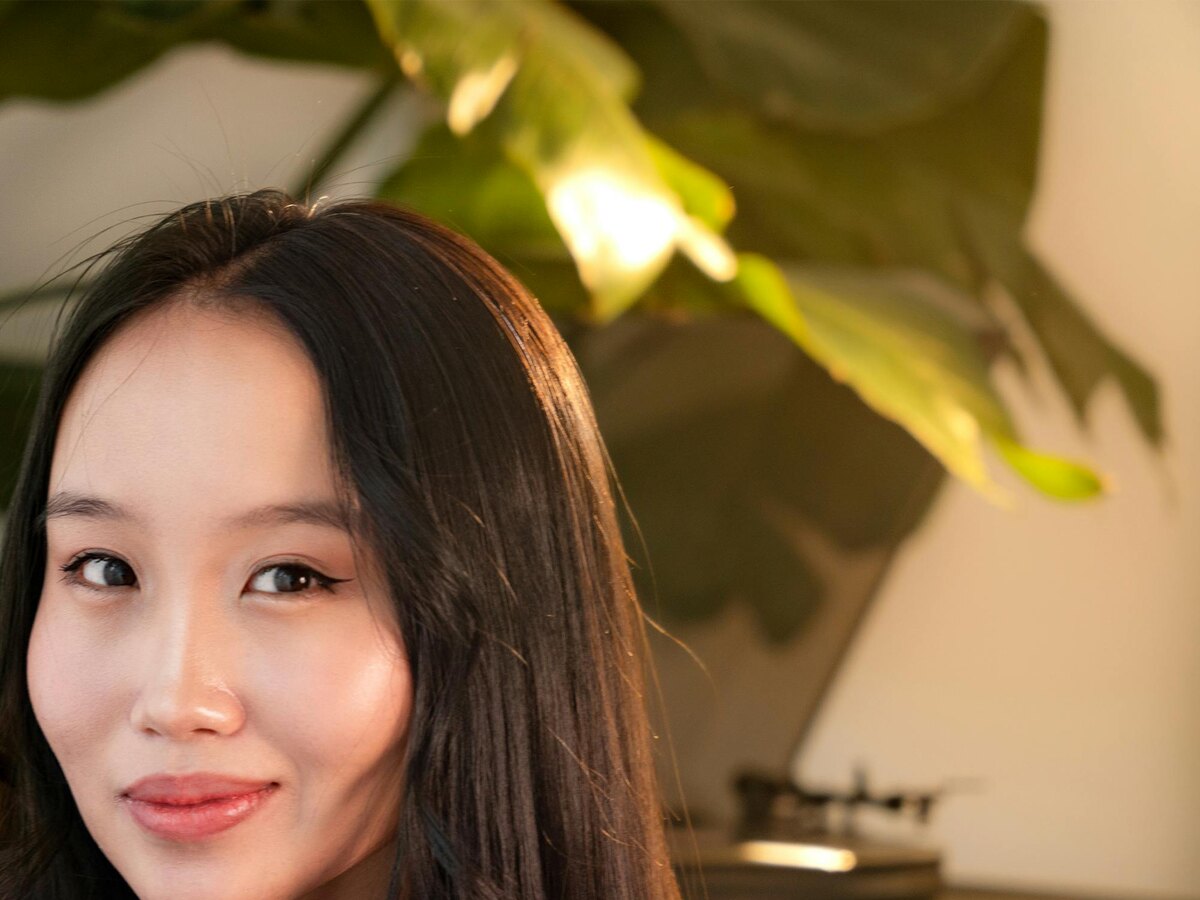 Woman with dark hair smiling in warm natural light